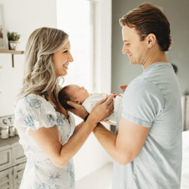 In home lifestyle newborn being held by mom and dad